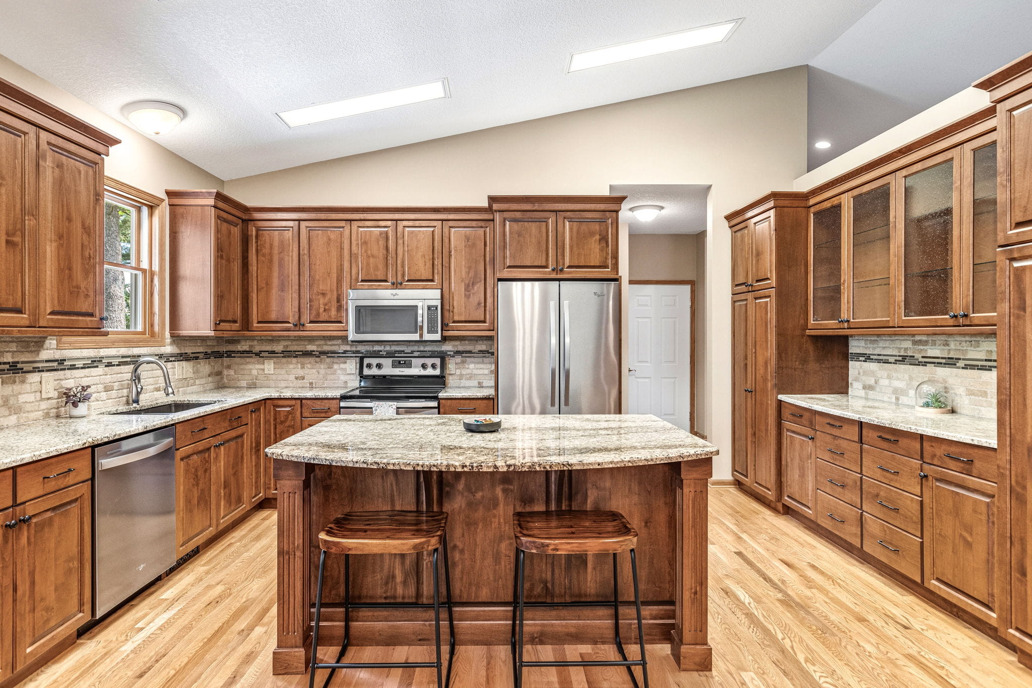 Updated kitchen with vaulted ceiling, granite counters, and center island